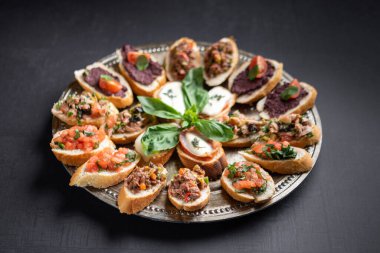 Lezzetli kanepeler, doğranmış sebzeler, krem peynir, et ezmesi.