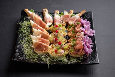 Çiçekler, böğürtlenler ve mikro-yeşillerle süslenmiş iştah açıcı tabaklar.