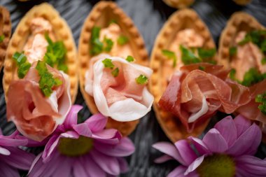 Prosciutto ve sebze püresiyle servis edilen kanepeler.