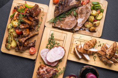 Izgara, fırın, kızarmış et, ahşap tahtalarda servis edilen kırmızı şarapla servis edilen et.