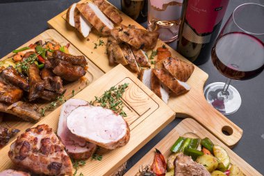 Ahşap tahtalarda servis edilen ızgara, fırın ve kızarmış et çeşitleri. 