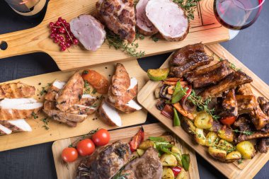 Ahşap tahtalarda servis edilen ızgara, fırın ve kızarmış et çeşitleri. 