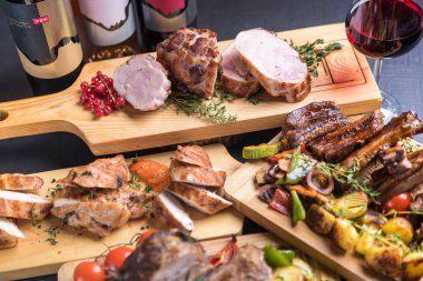 Ahşap tahtalarda servis edilen ızgara, fırın ve kızarmış et çeşitleri. 