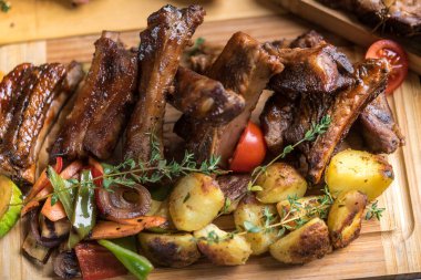 Patatesle servis edilen fırınlanmış et çeşitleri.