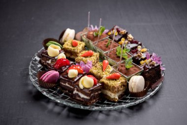 Şeffaf cam tabakta servis edilen küçük zarif tatlılar