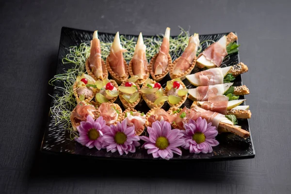 Stock image Festive platter with appetizers decorated with flowers, berries and microgreen