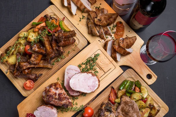 Izgara, fırın, kızarmış et, ahşap tahtalarda servis edilen kırmızı şarapla servis edilen et.