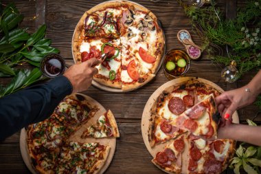 Bir çift tatil masasından pizza seçiyor.