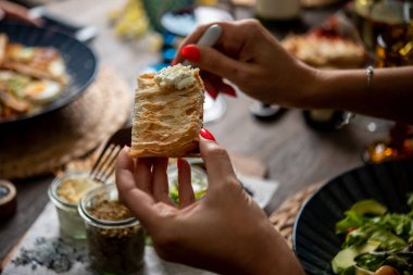 Ekmeğe sos döken bir kadın.