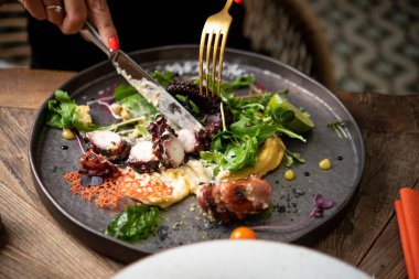 Kısmen ızgara ahtapot yiyen kadın manzarası