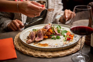 Garsonun bifteğe sos ve fırında patates ekleme görüntüsü.