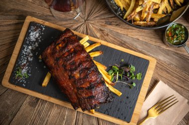 Kızarmış patates ve kırmızı şarapla servis edilen domuz pirzolası.