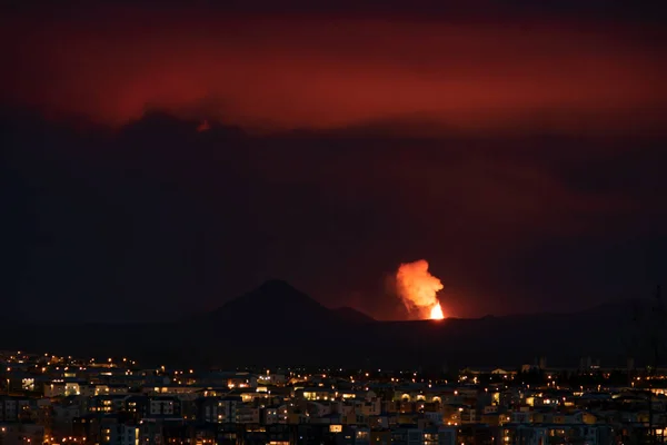 Volcano erupting over Reykjavik neighborhood houses