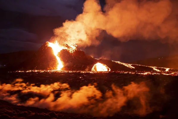 Volcano cone flowing lava down flanks, night landscape