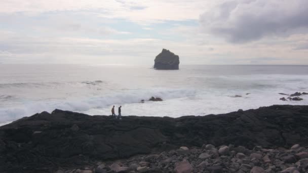 남자가 필름인 레이캬 파도와 바위가 해안선을 — 비디오