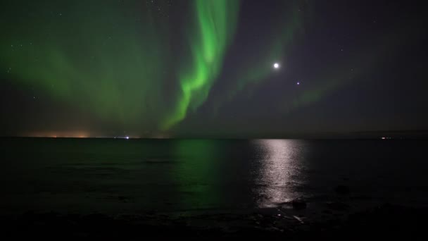 在月球和金星面前的海洋中反射的北极光 — 图库视频影像