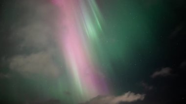 Aurora borealis parlak renkli ışık kuyusu ve geçen bulutlar