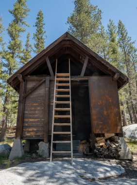 Yosemite Ulusal Parkı 'ndaki Karlı Devriye Kulübesinin çatısına tırmanan Uzun Merdiven