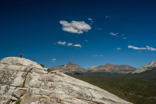 Yürüyüşçü Yosemite 'deki Lembert Kubbesi' nin tepesinde mola veriyor.