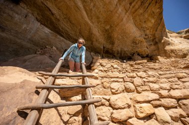 Mesa Verde Ulusal Parkı 'nda bir kadın merdivenin tepesinden aşağı bakıyor.