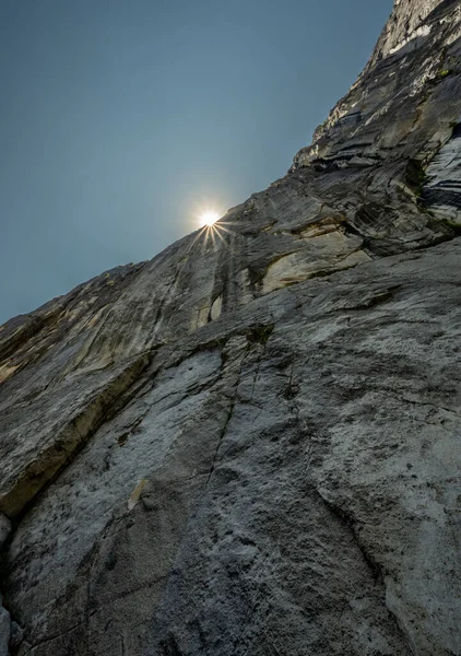 ヨセミテ国立公園の急な崖の壁の上に太陽がバースト — ストック写真
