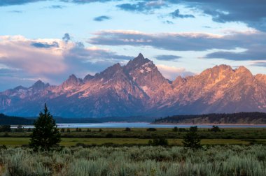 Grand Teton Jackson Gölü 'nün üzerinde yükseliyor Yazın gündoğumunda