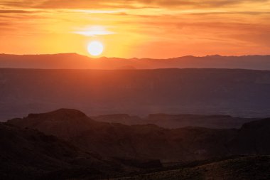 Big Bend Ulusal Parkı üzerinde batarken Turuncu Gökyüzü Güneş 'in etrafını sarıyor