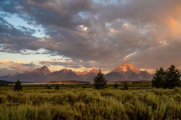 Warm Sun Hits The Snowy Peaks Of Tetons In Summer at dawn