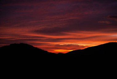 İlk turuncu ışık dalgaları şafak vakti Blue Ridge Dağları 'nın üzerinden gökyüzüne düşer.