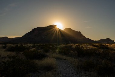 Güneş Chisos Dağları 'nın üzerinden Big Bend' in altındaki vadiyi aydınlatmak için doğar.