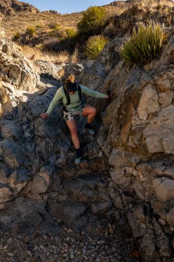 Sırt çantalı Big Bend Ulusal Parkı 'nda Kayalıklardan Aşağı Tırmanıyor
