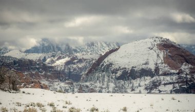 Zion Ulusal Parkı 'nda Kar Kaplamaları ve Tepeler Bulutlu Gökyüzünün Altında
