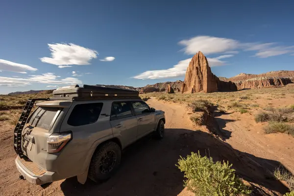 stock image Cathedral Valley, United States: June 20, 2023: Dirty Toyota 4Runner Sits On Road Leading to Temple Of The Sun and Temple Of The Moon