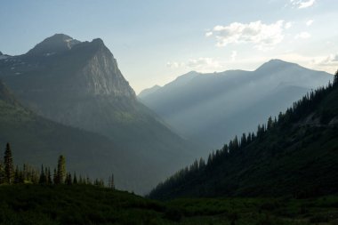 Buzul Ulusal Parkı 'ndaki Mount Cannon' ın altındaki Siluetli Katmanlara Işık Kırıldı