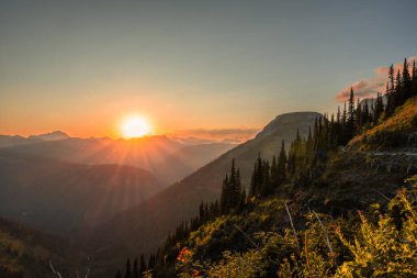 Parlak Turuncu Güneş, Buzul Ulusal Parkı 'ndaki Highline Trail' den Mesafeye Kıtasal Bölünme Altında Batıyor