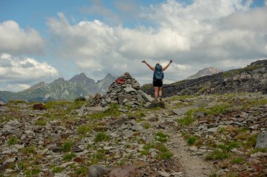 Backpacker Raises Hands In The Air When Reaching The Spray Park Cairn in Mount Rainier National Park clipart