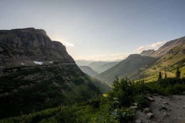 Mount Cannon Pushes Out Into View As Sun Rays Shine Into The Valley Below The HIghline Trail in Glacier National Park clipart