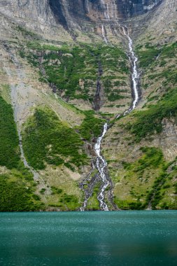 Uzun Buzul Federal Şelalesi, Buzul Ulusal Parkı 'ndaki Frances Gölü' ne doğru yeşil bir uçurumdan düşüyor.