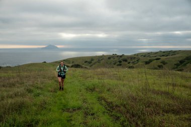 Mutlu Yürüyüşçü, Anacapa ile uzaktaki otlak patikasına tırmanır