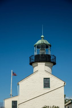 Güney Kaliforniya 'da Mavi Gökyüzüne Karşı Cabrillo Ulusal Anıtı' nın yanında Amerikan Bayrağı dalgalanıyor