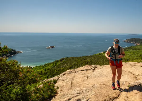 Champlain Dağı 'ndaki Granit Slab' e ulaşan kadın Atlantik manzaralı.