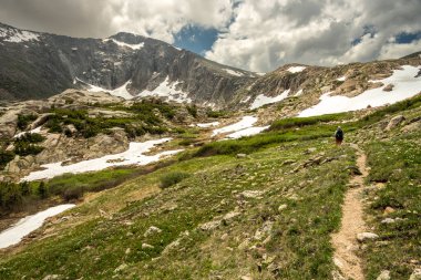 Rocky Dağı Ulusal Parkı 'ndaki Kristal Göl' e doğru ilerleyen yürüyüşçü