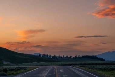 Yellowstone Ulusal Parkı 'ndaki Hayden Vadisi' nden geçen döngü yolu üzerinde akşam gökyüzü renginde patladı