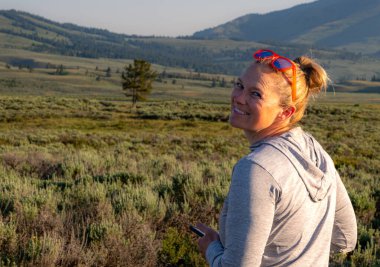 Yellowstone 'lu Kadın Akşam güneşinde Büyük bir gülümsemeyle Arkaya Bakar