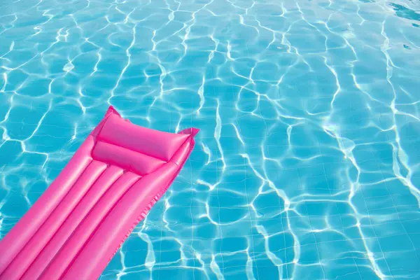 水面に浮かぶピンクのインフレータブルマットレス ストック写真