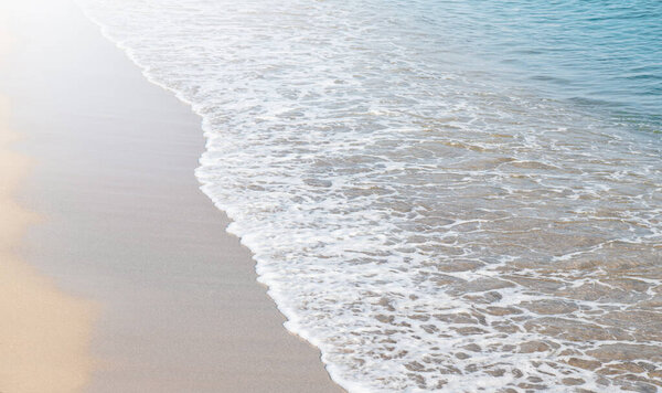 Soft wave of blue sea on sandy beach.