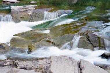 Taşlar ve küçük şelaleli dağ nehri, bulanık arkaplan