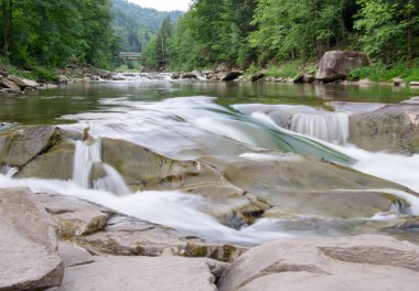 Taşlar ve küçük şelaleli dağ nehri, bulanık arkaplan