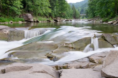 Taşlar ve küçük şelaleli dağ nehri, bulanık arkaplan