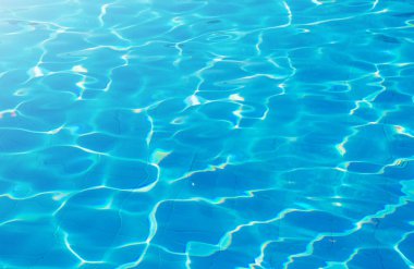 Mavi yüzme havuzunun yüzeyi, yüzme havuzundaki suyun arka planı.